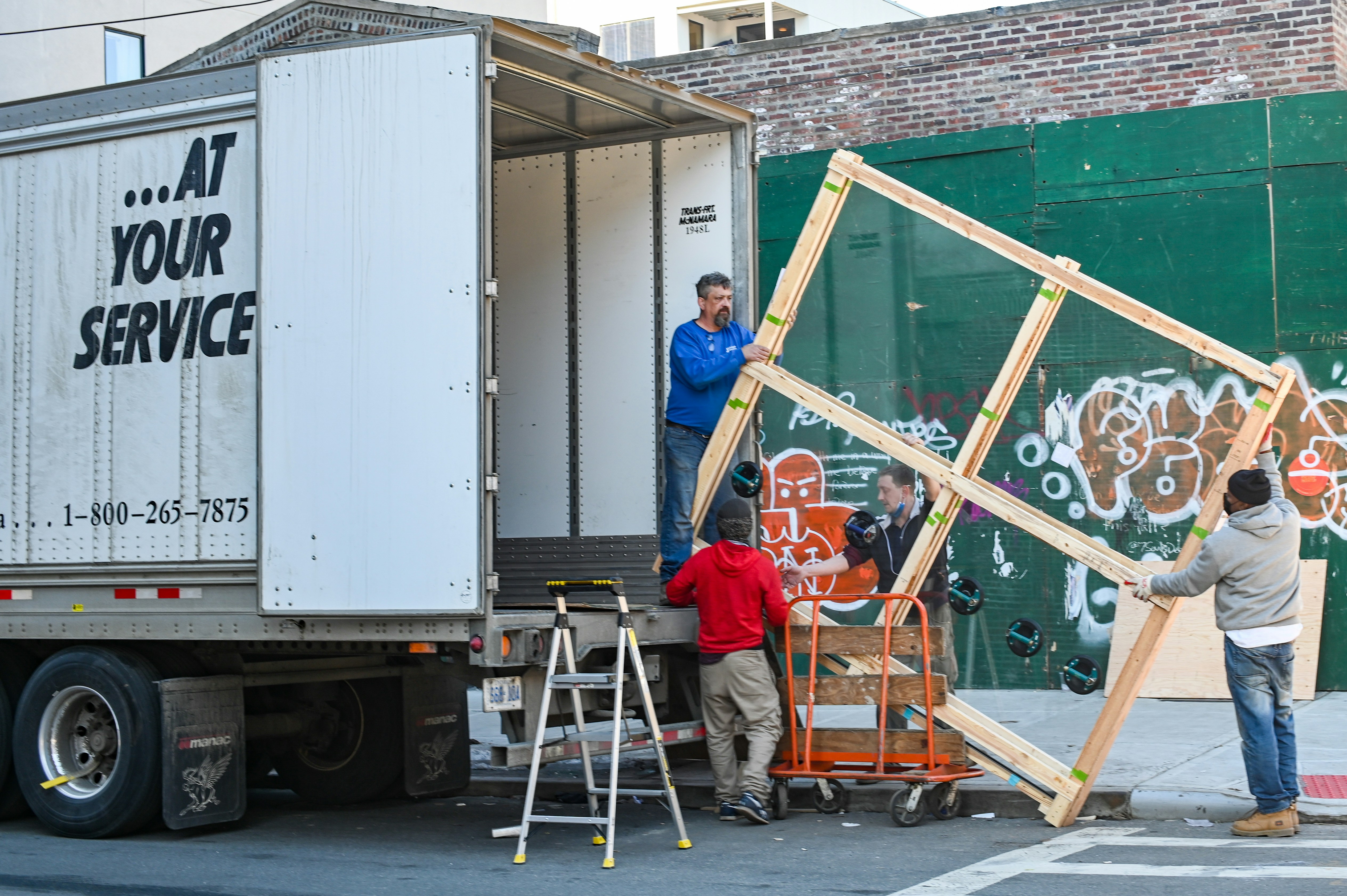 Cover image for the post. Four movers preparing to load a large, framed item onto a truck. Photo taken by Robinson Greig.